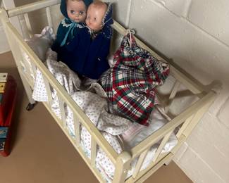 Here’s a vintage doll crib with dolls to go with it