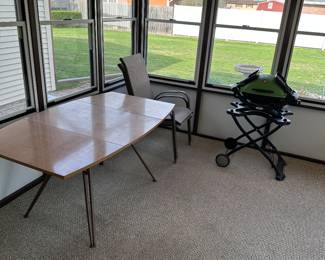 The sunroom doesn’t have a lot in it, but what it does have is excellent! To the left is a beautiful drop leaf mid-century modern table, a couple of great vintage lawn chairs and an excellent Weber grill!