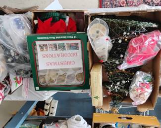Multiple boxes of Christmas decorations, artificial trees, lights, ornaments, wreaths, village figurines. All things Christmas