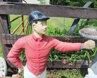 painted concrete jockey standing on a base 14" x 14" and 44" tall, his arm is wired for a light