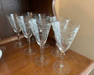several sets of etched stemware in various sizes and patterns