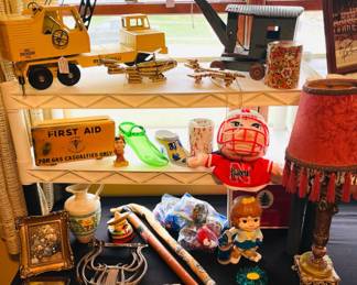 Trench art, vintage pool cue/walking stick, vintage metal toy trucks/machines, lucite flower decor, metal bench legs, gas casualties first aid container, vintage art