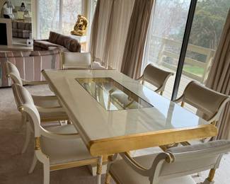 Custom modern design gold and opaque white dining room table with glass center. Comes with 6 chairs and 2 leaves to extend to 112 inches long! Chairs are very comfortable with rolled backs and gold accents. Stunning statement furniture. Table is 76 inches by 44 without leaves, each leaf is 18 inches wide.
Chairs are 3 ft high, 22 inches wide and seat height 19 inches.