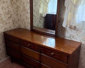 This is a beautiful mid-century modern nine drawer dresser with mirror! Made by Bassett furniture industries Inc.
