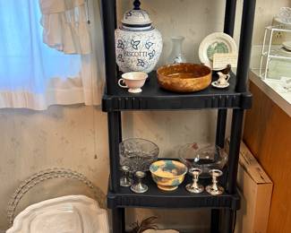 This is a shelf of lovely vintage items! Down the left-hand corner of the picture are some enormous oversized platters!