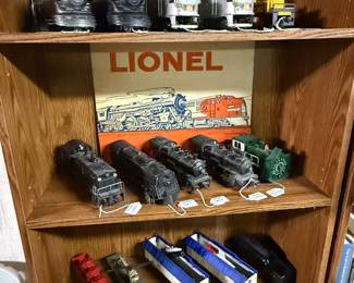 This is rack for filled with mostly beautiful vintage Lionel train engines! Two of my favorite pieces are there on the bottom third shelf with the blue tops. There are terrific missiles inside those cars.! Clearly post world war maybe even the Cold War era!