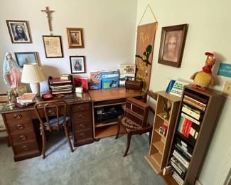 A desk with chair, computer stand, books, and a nice printer with accessories! This room also contains a lot of religious items from both the Christian and Judaism faiths!