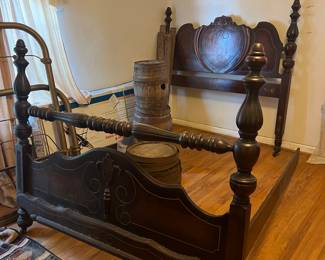 Antique Ornate Wooden Bed Frame - Full size, beautifully detailed antique full-size bed with high headboard, carved medallion centerpiece, turned posts, and scalloped footboard with rich dark wood finish and craftmanship make this a standout piece for a vintage or traditional bedroom.