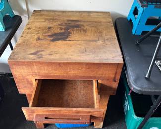 Butcher block cutting table with drawer open.