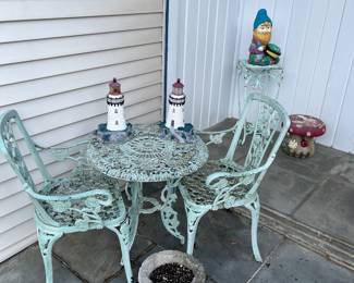 Iron table and chairs, ceramic light houses-mushroom-gnome and iron plant stand.