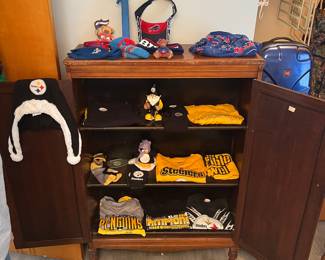 Walnut hutch with doors open with Pittsburgh Steelers and Buffalo Bills collectibles.