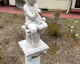 White garden stone depicting an Angel carrying a bird. Beautiful details to enhance your outdoor space.