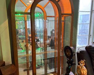 3 Available- Beautiful arched and lighted curio display cabinets with glass shelves in excellent condition.