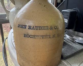 Antique stoneware jug. Features John Rauber & Co. Rochester, NY, indicating the merchant who made it. Made of durable, non-porous ceramic fired at high temperatures. Great for collectors and decoration. 