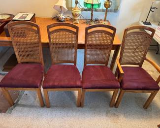 Set of 4 dining chairs. Wooden cane back with padded maroon colored velour seats. Dining table w/ 2 leaves.