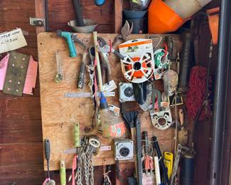 Collection of garden tools, funnels, wires and brushes.