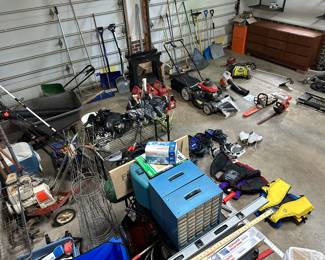Garage full of tools including lawnmower, leaf blower, weed eater, chain saws, wheelbarrow, seeder, garden tools, life jackets, roller blades, snow shoes, gardening pots, and more!