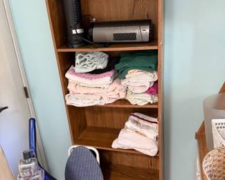 bookshelf, vacuum, ironing board, towels, space heaters