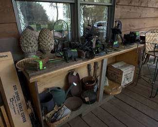 Front porch full of cast iron, tools, old pump, etc.