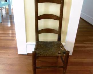 Child ladder back, rush bottom chair. Back is about 3 and a half inches. Located in living room.