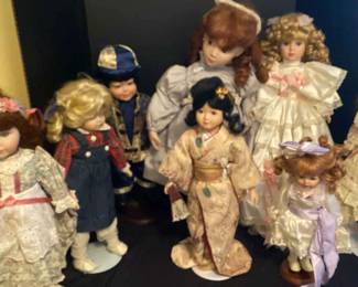 A large lot of porcelain dolls on stands