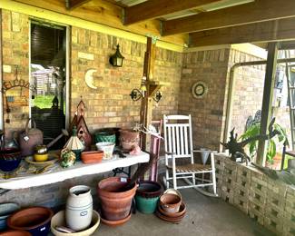 White wooden rocker, pottery, planters, bird houses, backyard decor.