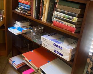 Mahogany book shelf loaded with books and office supplies