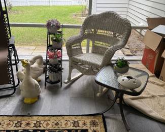 Plant stands, wicker rocker, lots of rugs, ceramic geese