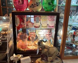 The two pitchers on top of this showcase are vintage Bohemian Czech, Mary Gregory, Cranberry and Green. The stemware and Highballs inside are Ebeling & Reuss Marchioness. The Smiley Pig is Shawnee.