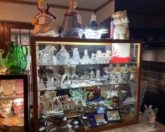 On top are McCoy Red Riding Hood Cookie jars and Puss In Boots Cookie Jar. Top shelf holds Baccarat, Waterford, Czech, and German Perfume Bottles.
