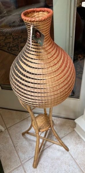 Hand woven basket on a stand.