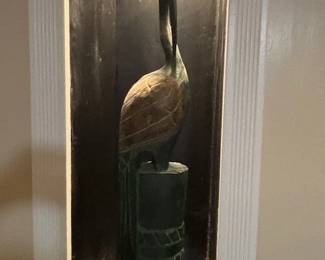 Carved heron on post.