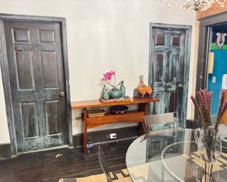 This is the matching console table to the one with sliding doors. It has one shelf. The green patinaed metal vases, "russian" puppet, baskets, glass pitcher and boxes are all for sale.