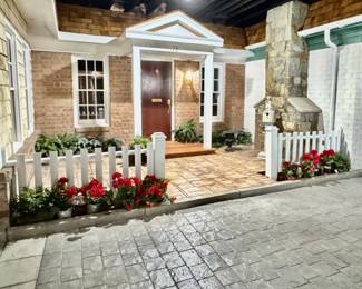 Birdhouse, iron planter, and faux floral arrangements