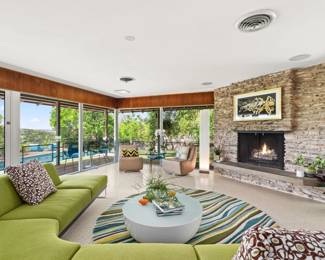 Living room: wrap-around sectional sofa, houseplants, original art