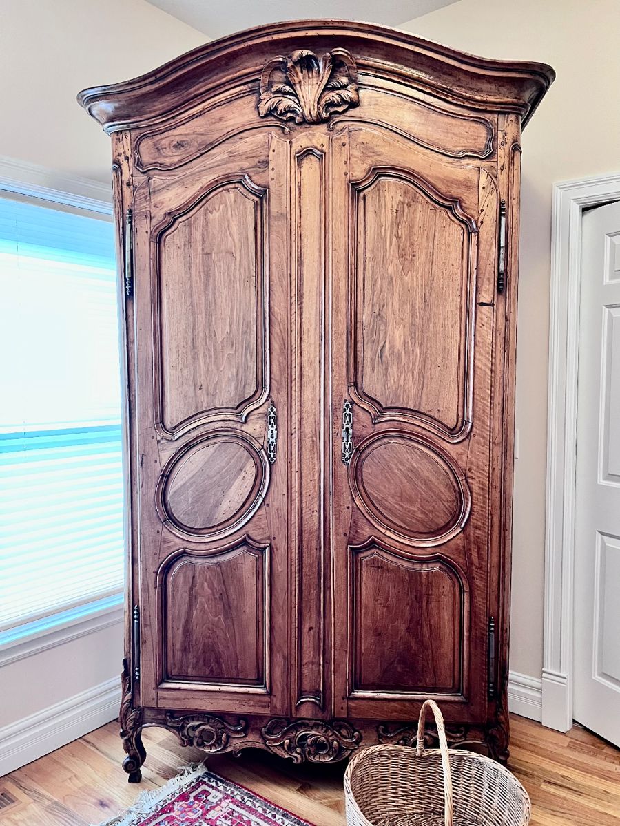 19th Century Antique French Louis XV Armoire. Crafted from rich walnut wood. This original antique, dating back to approx. 1870, reflects the intricate style of the Louis XV period. With its solid wood finish and historic value, this armoire is a testament to the craftsmanship of the late 19th century.