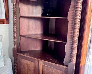 Antique tall corner cabinet with stacked bobbing pillers