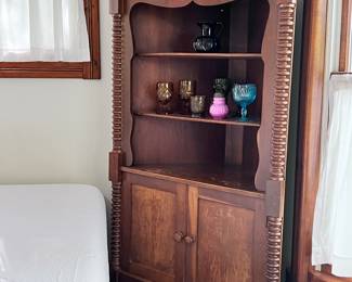 Antique tall corner cabinet with stacked bobbing pillers