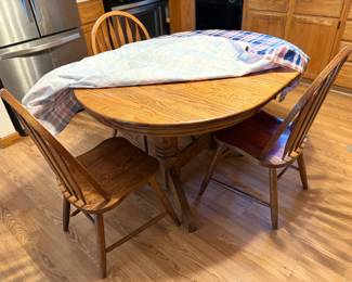 . . . oak dining room table and three chairs