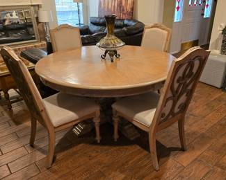 Contemporary round wood dining table with 4 upholstered, designed back chairs