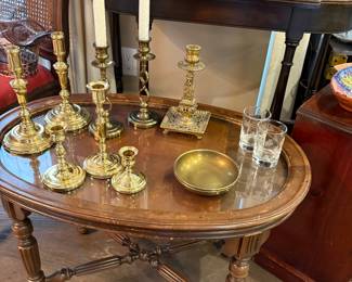 Round side table with glass top and shown with brass candle holders