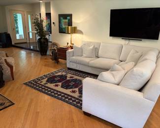 Another view of the Burton James sectional, area rug, leather topped side table and brass lamp