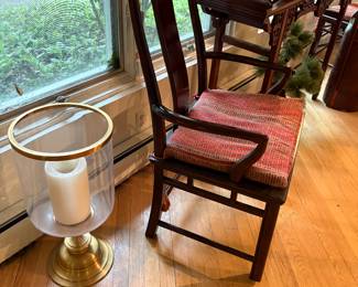 Armchair with dining table and large brass and glass hurricane candle holder