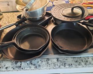 Various cast iron skillets and other cooking pans etc