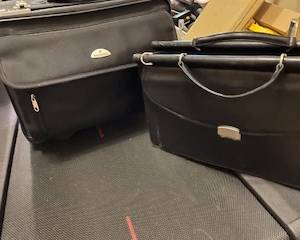 All leather, black briefcase and rolling litigation bag.