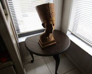 Egyptian bust on 3 legged drop leaf table