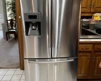 Samsung French door fridge with bottom freezer and built-in water/ice dispenser. Sleek stainless steel design. Clean and in excellent working order.