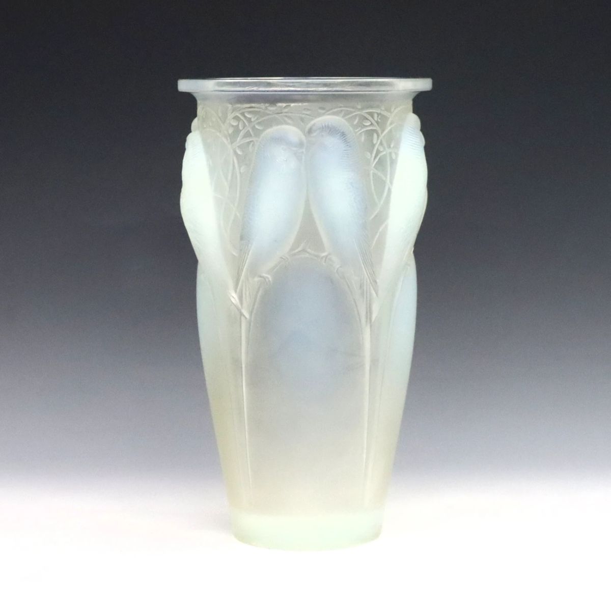 A 1920's Rene Lalique "Ceylan" glass vase. Opalescent glass with tapered form and molded songbird design. Wheel cut "R. Lalique France" mark and incised model "905". Minor surface wear, a few micro-flakes along edges of body. 9 1/2" high.