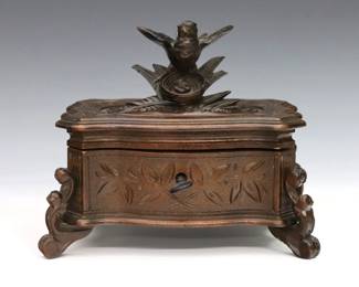 A turn of the century Black Forest box. Walnut construction with a carved bird and next above lower foliate panels on a molded base. Older refinishing, repaired bird. 6 1/4 x 4 x 5 1/2" high overall.