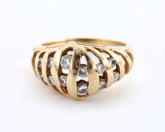 A vintage Traub Orange Blossom 14k Gold and Diamond ring. Features a domed setting with openwork design and twelve round cut channel set Diamond accents. Marked "Orange Blossom" and "14k". 3.9 troy ozs total. Minor surface wear. Size 5.